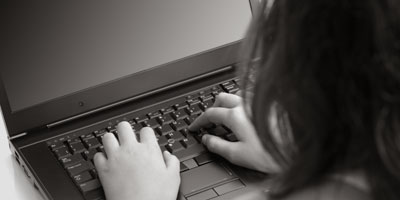 person with hands at laptop keyboard